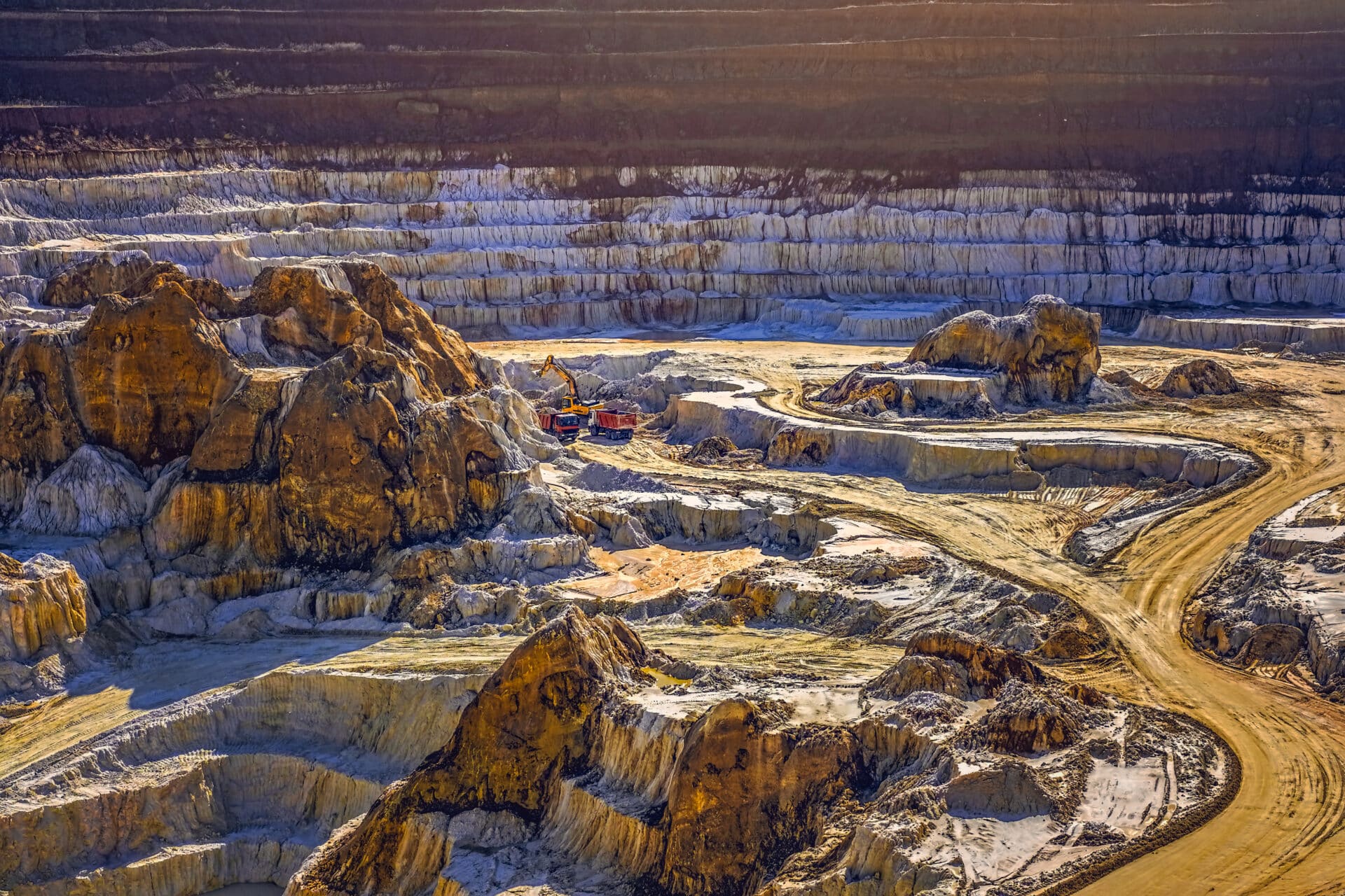 Excavator loading dump truck with raw kaolin in kaolin open pit mine