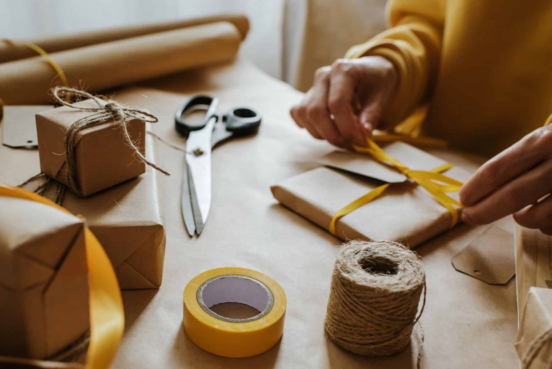 Woman packaging box. Kraft wrapping paper and natural twine. Recycling material. Happy holiday present, surprise. Gifts for boxing day. Delivery service, shipping. Handwork art craft. Celebration